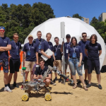 Zdjęcie studentów ze Studenckiego Koła Astronautycznego wraz z łazikiem marsjańskim 