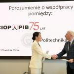 Na zdjęciu prof. Mariusz Malinowski, Prorektor ds. Nauki oraz Agnieszka Szczygielska, Dyrektorka CIOP-PIB stoją na tle ekranu i ściskają sobie dłonie