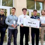 Na zdjęciu siedmiu studentów stojących na tle budynku