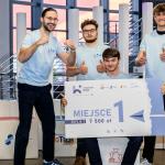 Na zdjęciu czterej młodzi mężczyźni z czekiem za zwycięstwo w Hackathonie StartupHack