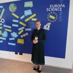 Na zdjęciu prof. Kamila Sałasińska na tle niebieskiej ścianki 