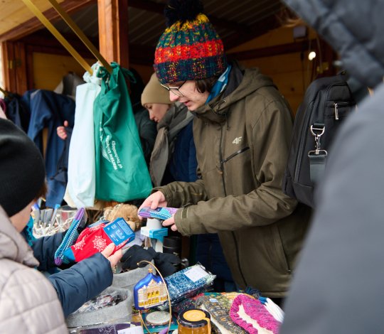 Na zdjęciu ludzie przy domku PW podczas Kiermaszu Świątecznego PW